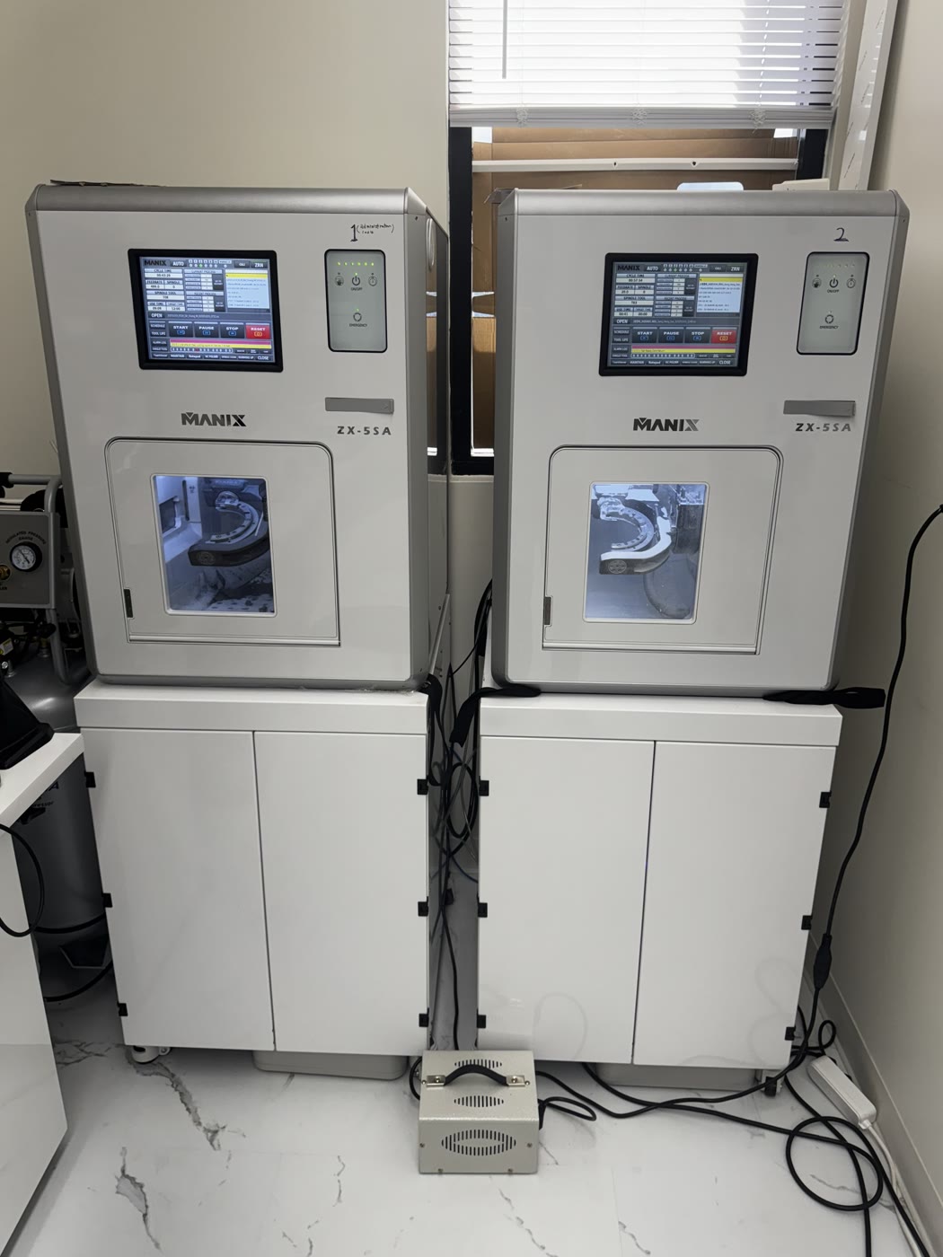 Two 5-axis milling machines cutting full-arch zirconia