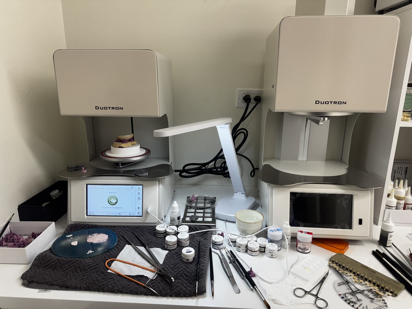 Porcelain furnaces, ceramic powders and a shade guide on the esthetic bench